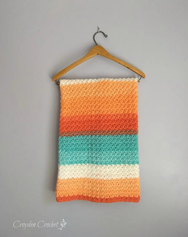 Everyday Crochet Baby Blanket on a hanger