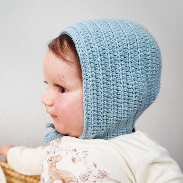 a baby wearing a crochet bonnet