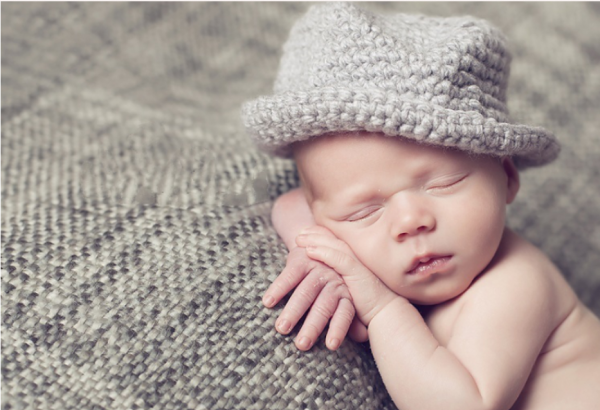 a baby wearing a fedora crochet hat