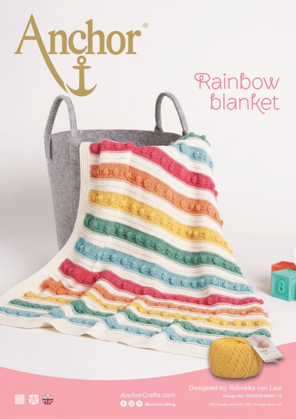 Crochet rainbow baby blanket in a gray basket